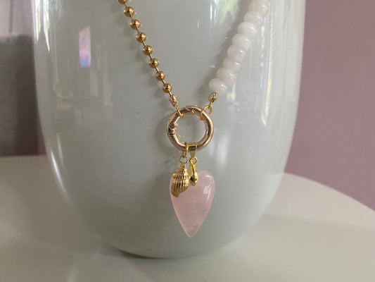 Detailfoto van Handgemaakte hoogwaardige ketting van enerzijds RVS materiaal en anderzijds wit natuursteen met een connector en daaraan 2 bedels.