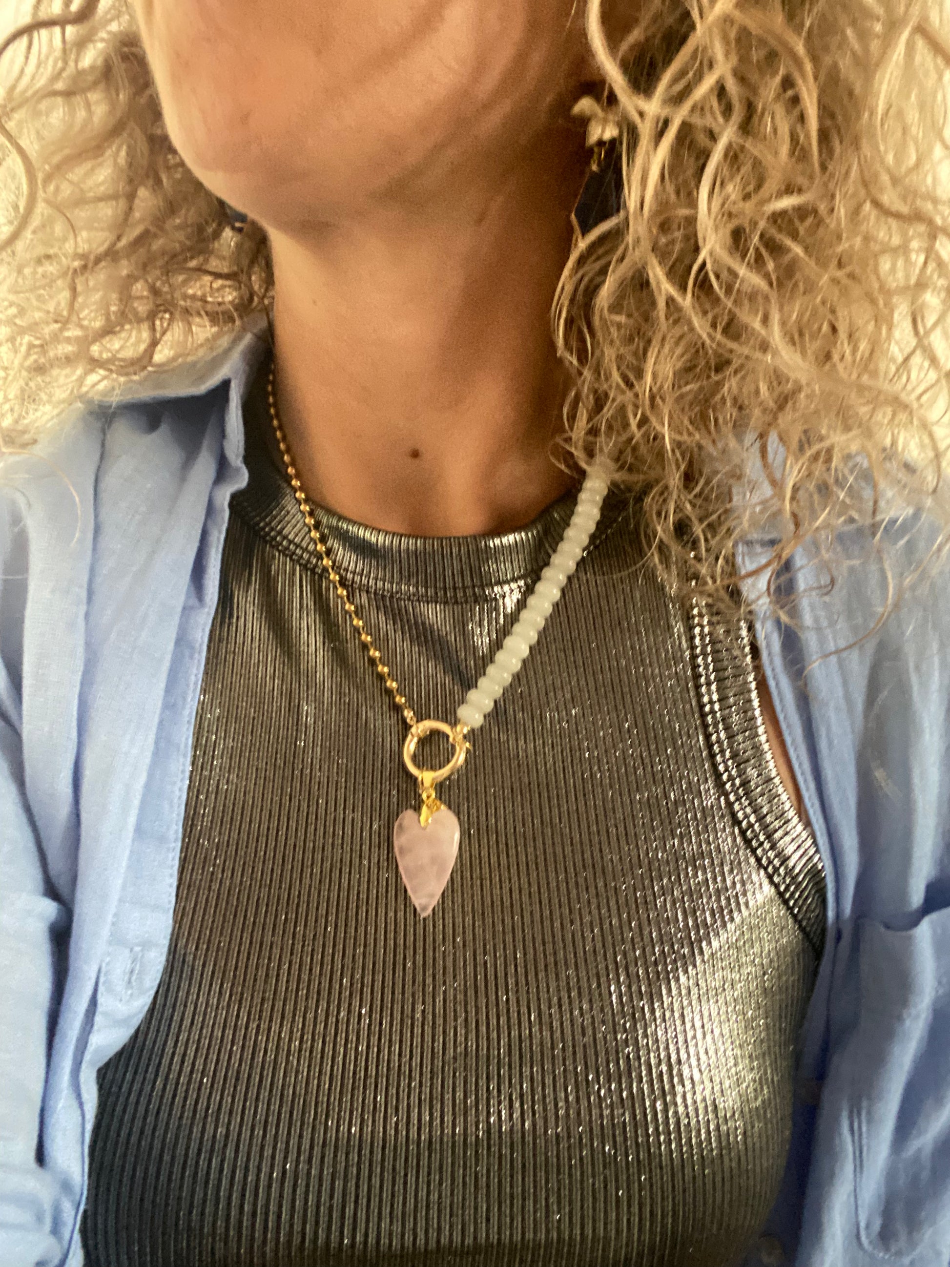 Model met Handgemaakte hoogwaardige ketting van enerzijds RVS materiaal en anderzijds wit natuursteen met een connector en daaraan 2 bedels.