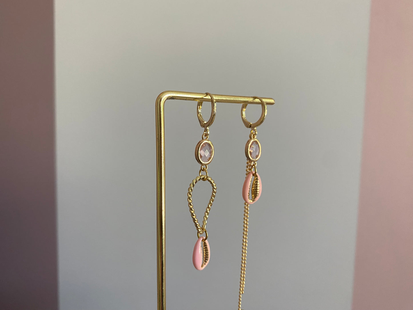 Handgemaakte asymmetrische zomeroorbellen in 14K verguld goud met kleine zachtroze glasbedels, vergulde gouden bedels en zachtroze schelpen.
