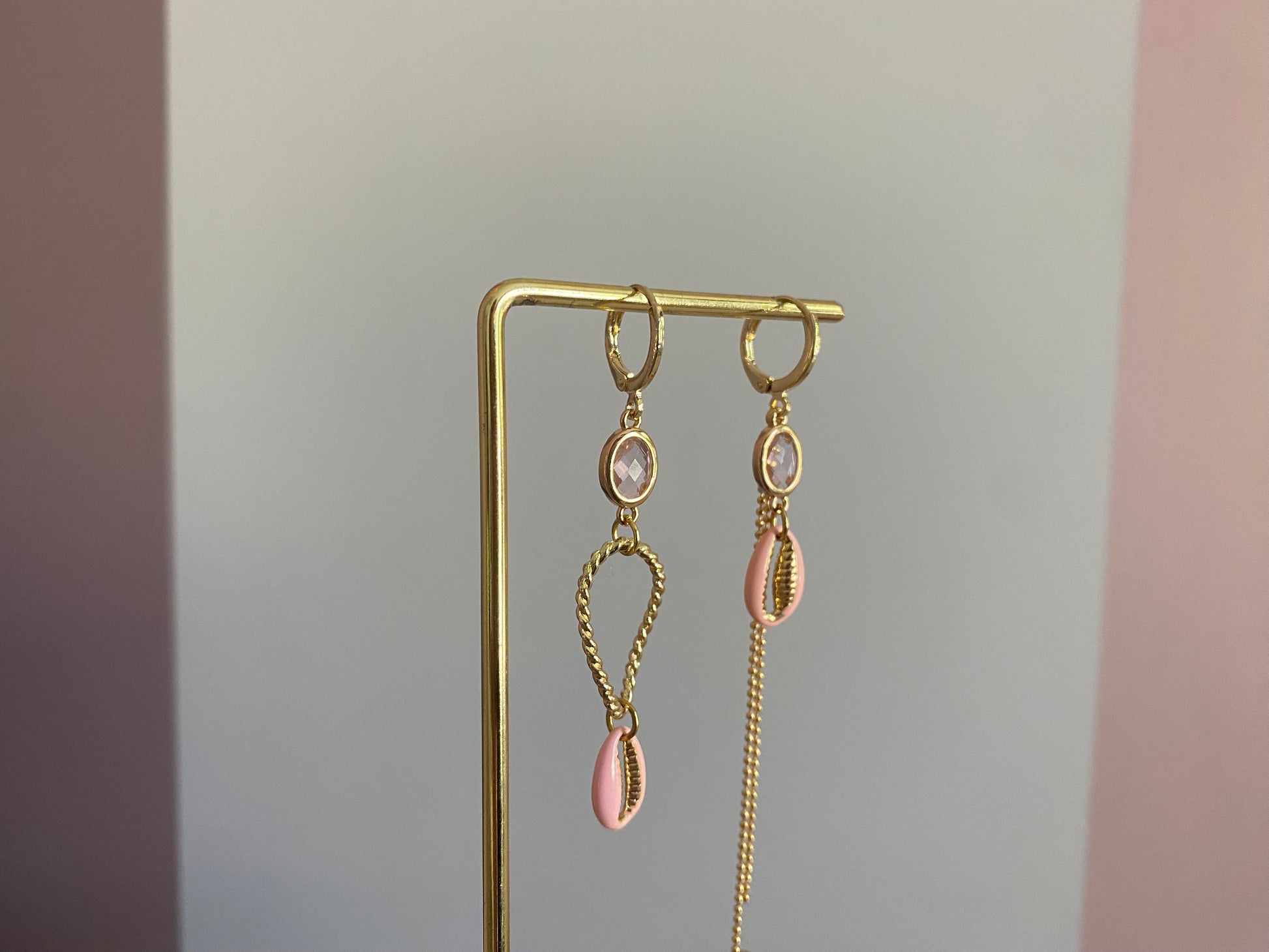 Handgemaakte asymmetrische zomeroorbellen in 14K verguld goud met kleine zachtroze glasbedels, vergulde gouden bedels en zachtroze schelpen.