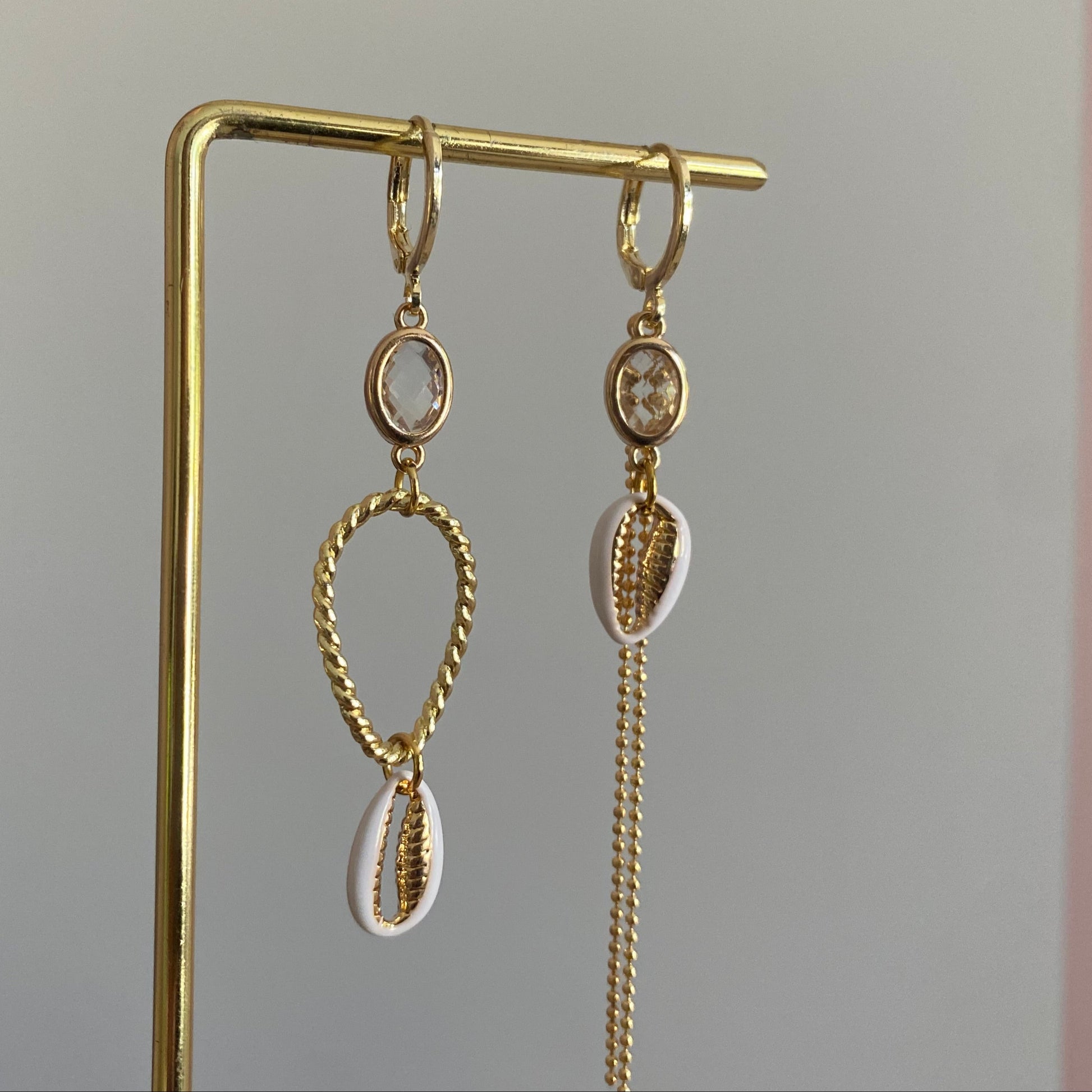 Handgemaakte asymmetrische zomeroorbellen in 14K verguld goud met kleine transparante glasbedels, vergulde gouden bedels en witte schelpen.