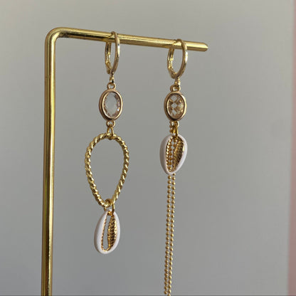 Handgemaakte asymmetrische zomeroorbellen in 14K verguld goud met kleine transparante glasbedels, vergulde gouden bedels en witte schelpen.