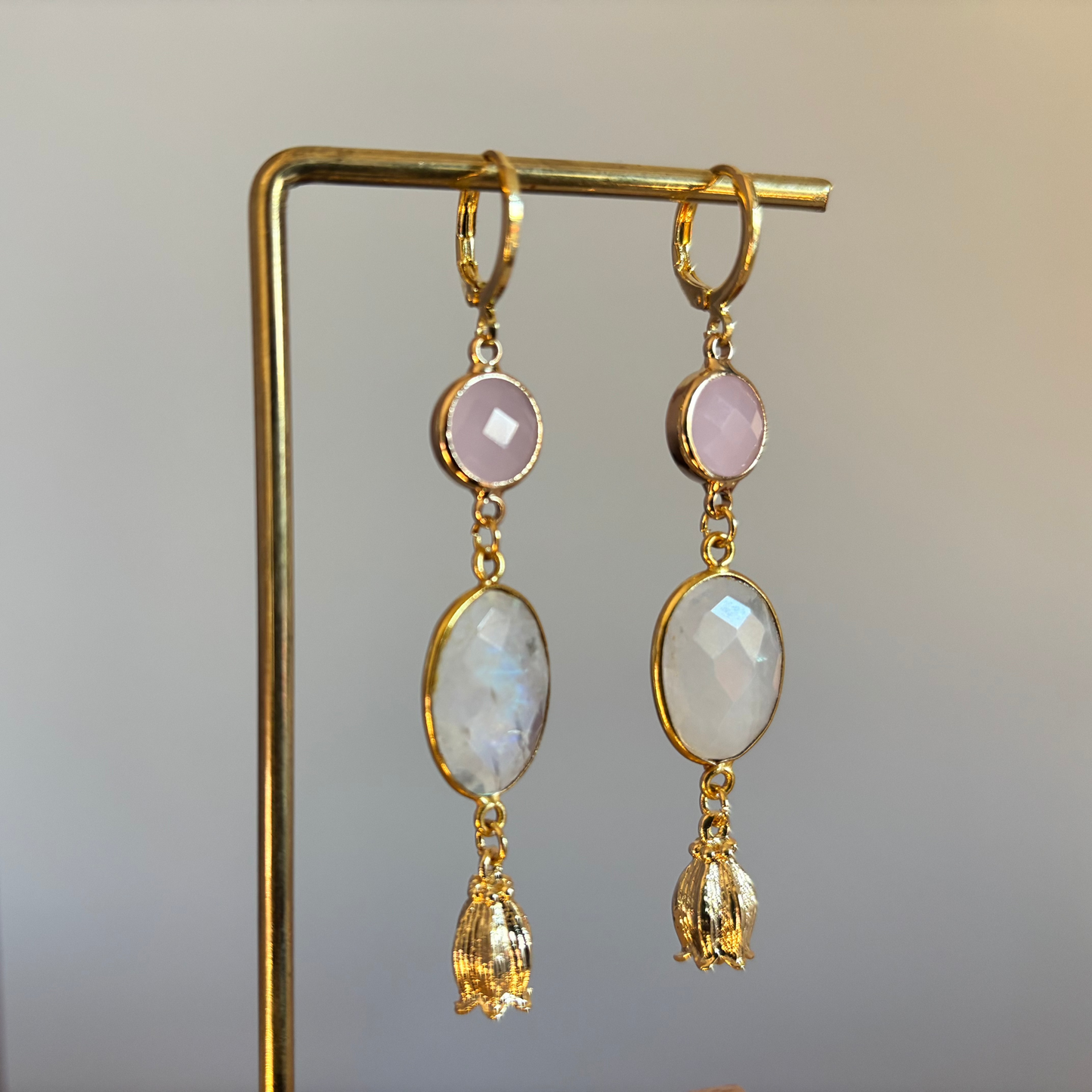 14k vergulde oorbellen met roze en witte facetstenen, afgewerkt met goudkleurige bloemkelkjes. Een rustig ontwerp voor dagelijks gebruik.