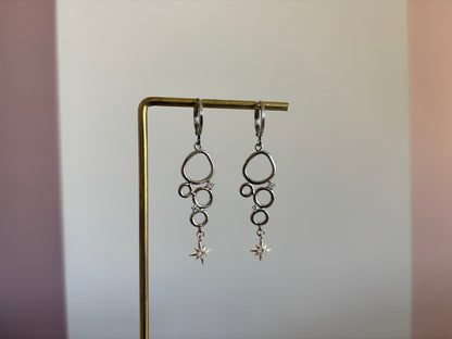Minimalistische bedel met meerdere cirkeltjes met zirkonia en een klein zirkonia sterretje, circa 4 cm lang.