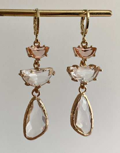14K vergulde ringetjes met perzikkleurige halve maan glasbedel, een transparante halve maan glasbedel en een asymmetrische transparante langwerpige glasbedel.
