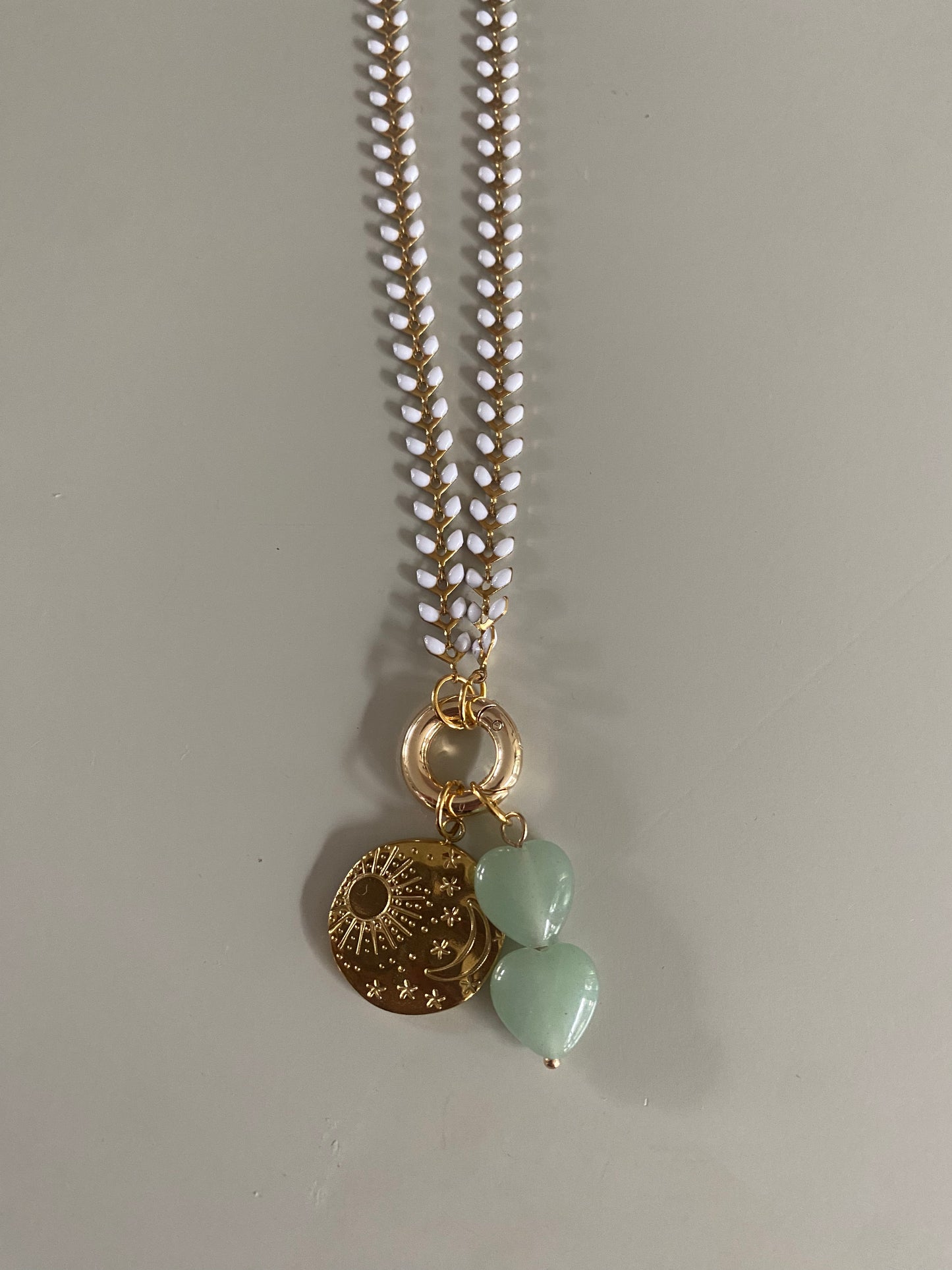 Emaille witte blaadjes ketting met daaraan een connector en 18K vergulde zon maar sterren bedel en 2 jadegroene natuurstenen hartjes aan een connector.