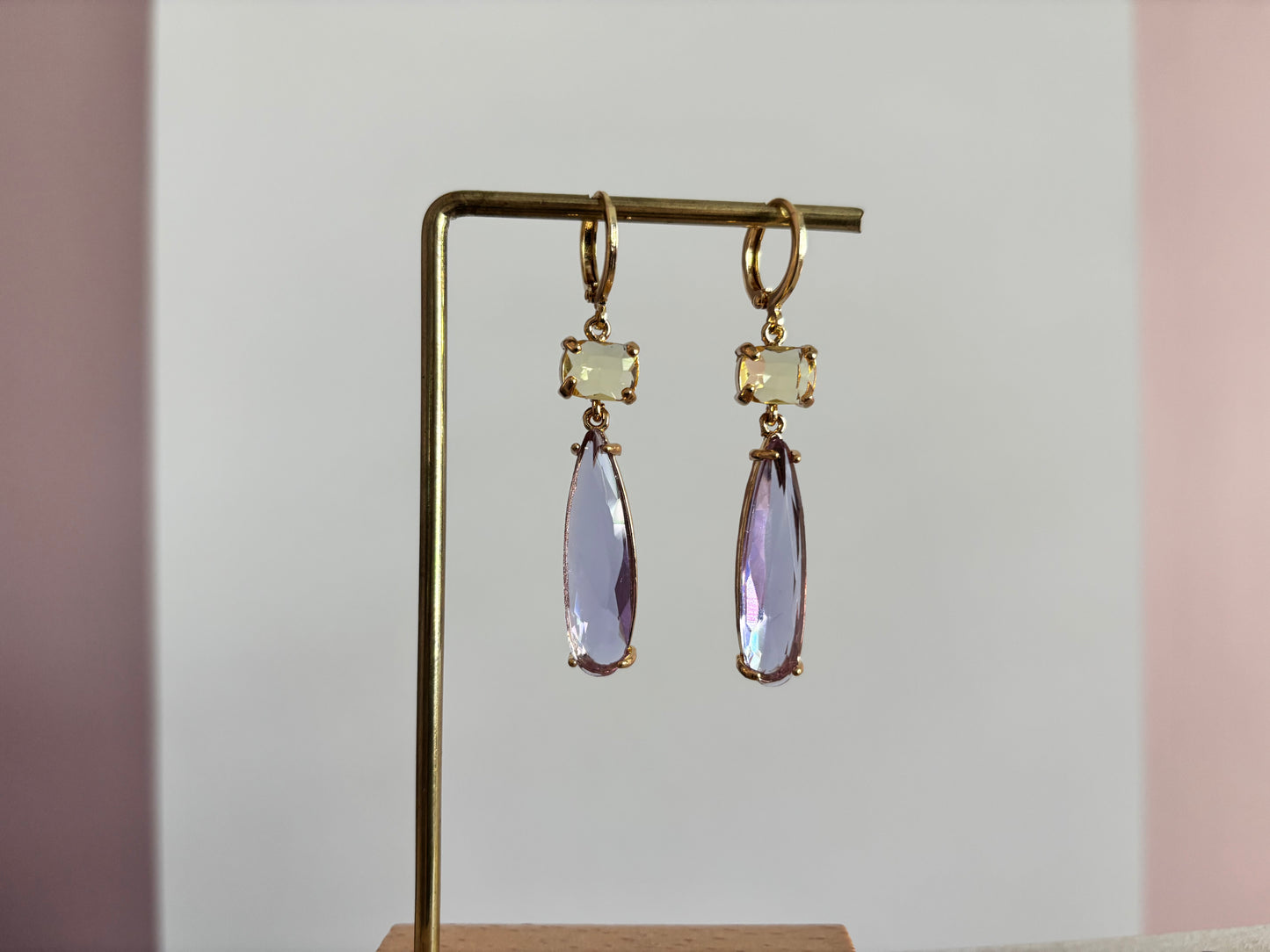 14k vergulde oorbellen model Maya met een vierkante gele kristallen steen en een hangende, lila druppelvormige kristalsteen.