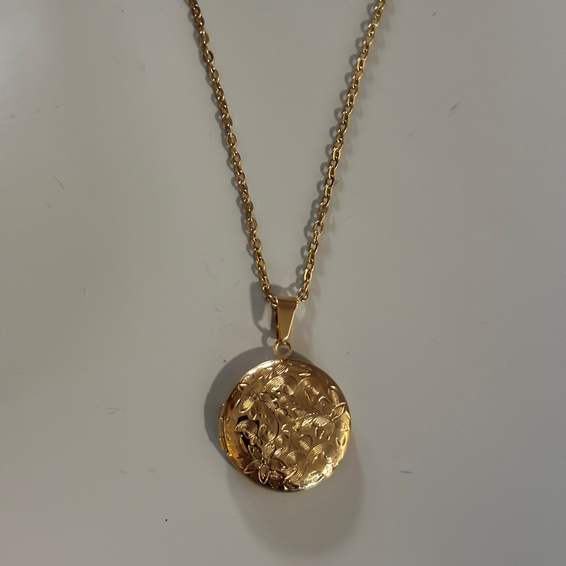 Drie medaillons: rond, ovaal en shell-vierkant, met ruimte voor een foto, op 14k vergulde kettingen van 45 en 60 cm.