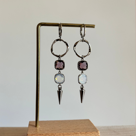 Zilverkleurige 'Melly Blauw' oorbellen met een burgundy en opal vierkante steen en een zilveren kegelbedel. Comfortabele, lichtgewicht oorbellen.