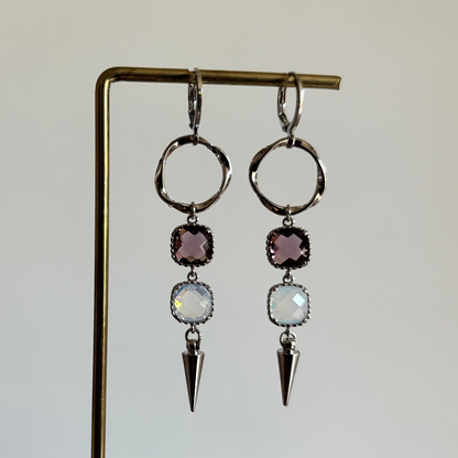 Zilverkleurige 'Melly Blauw' oorbellen met een burgundy en opal vierkante steen en een zilveren kegelbedel. Comfortabele, lichtgewicht oorbellen.