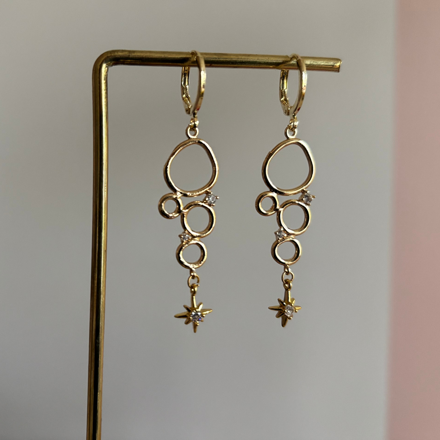 Minimalistische bedel met meerdere cirkeltjes met zirkonia en een klein zirkonia sterretje, circa 4 cm lang.