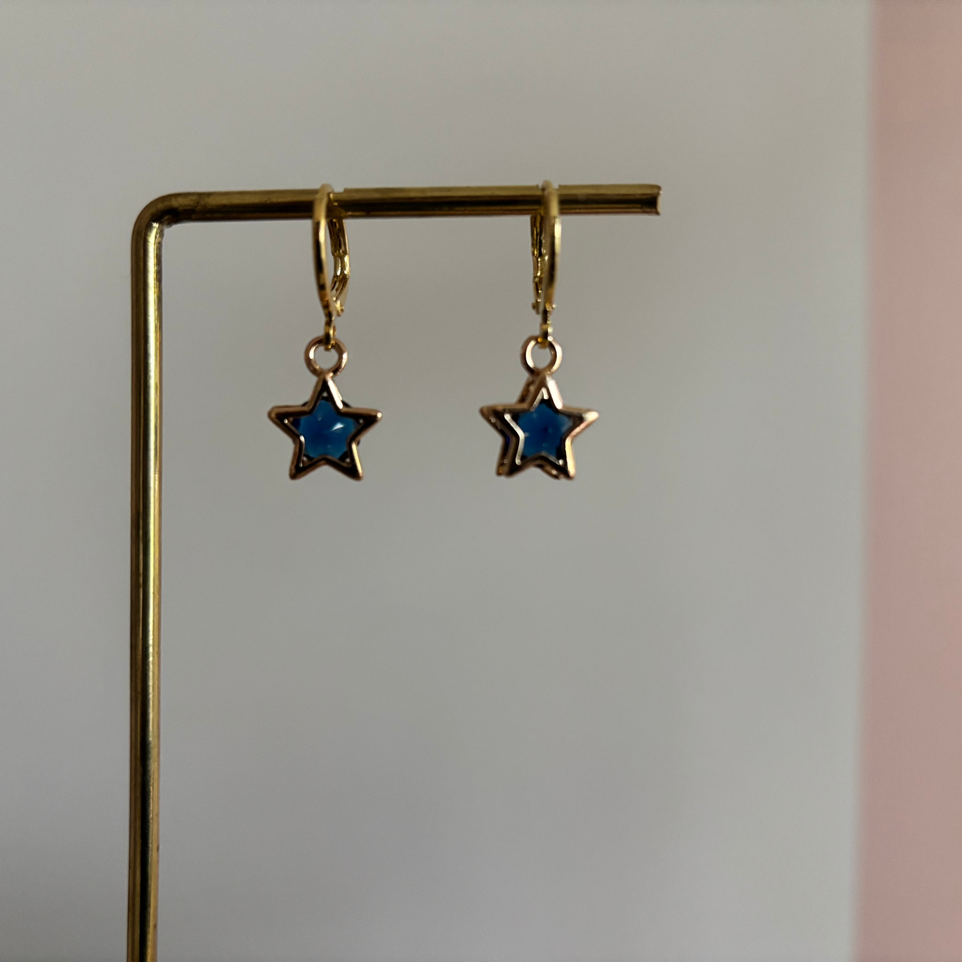 Mini sterbedel met donkerblauw zirkonia steentje in het midden.