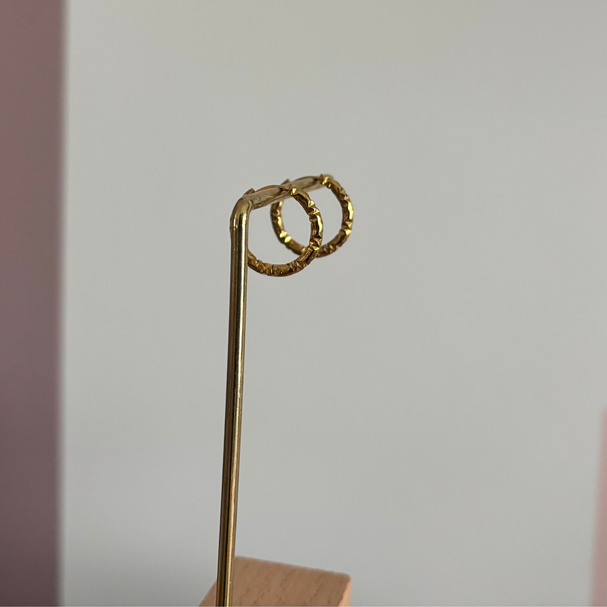 Alt-tekst: 18K goudkleurige creolen van 14 mm met een stoer bewerkt effect in de plating.