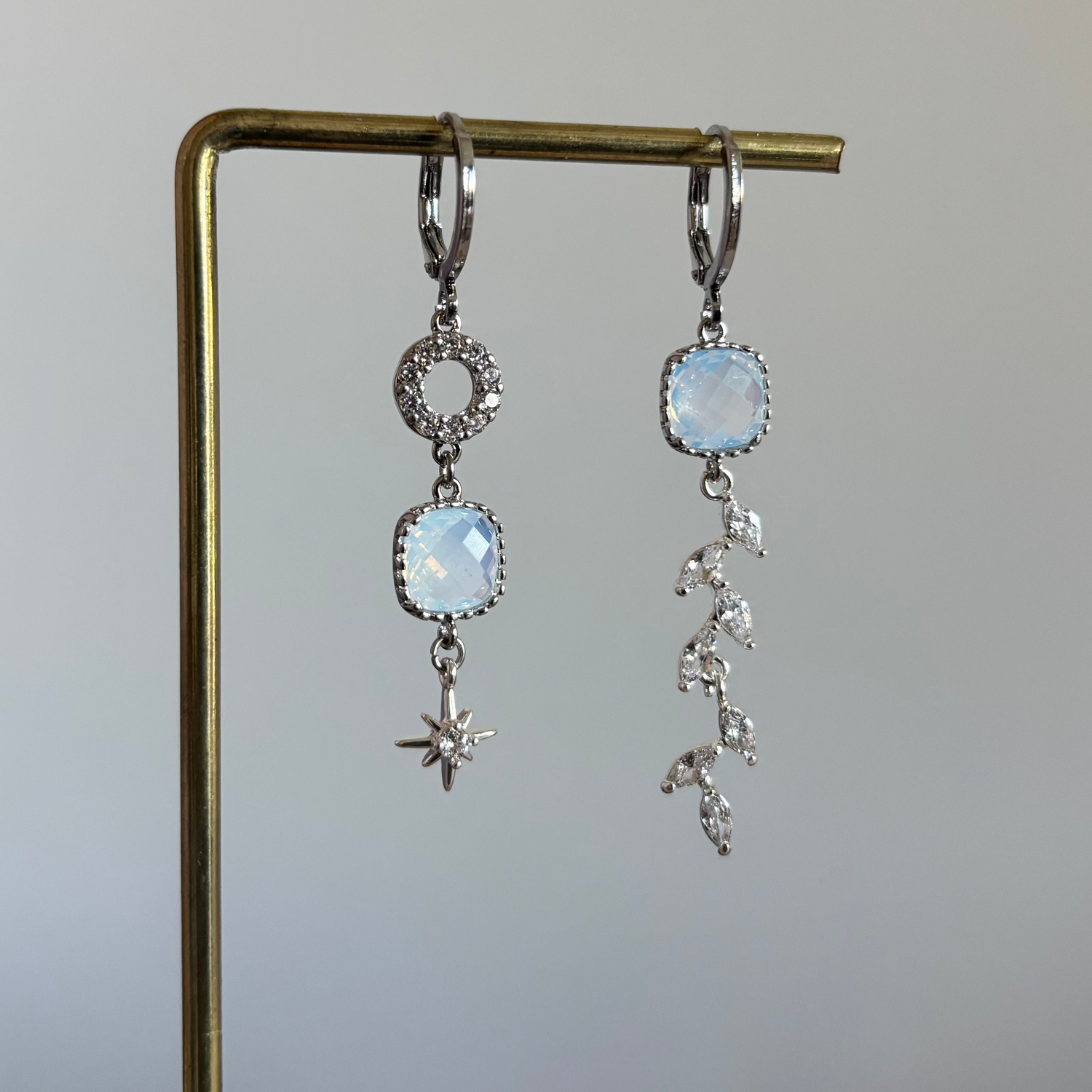 Zilveren mismatch oorbellen met ronde zirkonia, vierkante opaal en sterretje links en zirkonia strengetje rechts