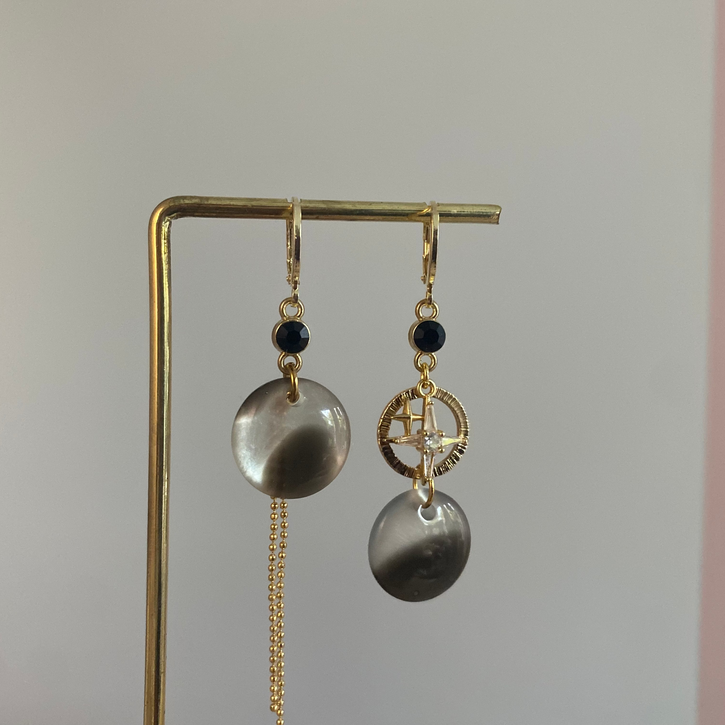 Asymmetrische 14k vergulde oorbellen met koeprint cabochon, zwart steentje, kwastje, gehamerde ring en zirkonia ster, ca. 4 cm lang