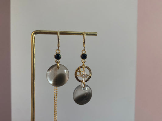 Asymmetrische 14k vergulde oorbellen met koeprint cabochon, zwart steentje, kwastje, gehamerde ring en zirkonia ster, ca. 4 cm lang