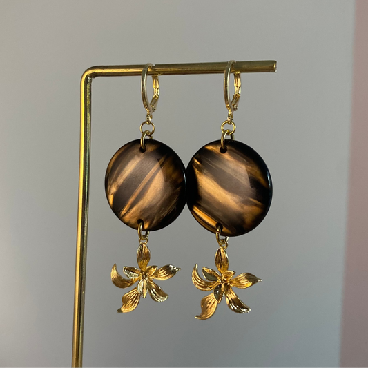 14k vergulde oorbellen met donkerbruine cabochon met tijgeroog effect en 14k vergulde bloem hanger, ca. 5 cm lang.