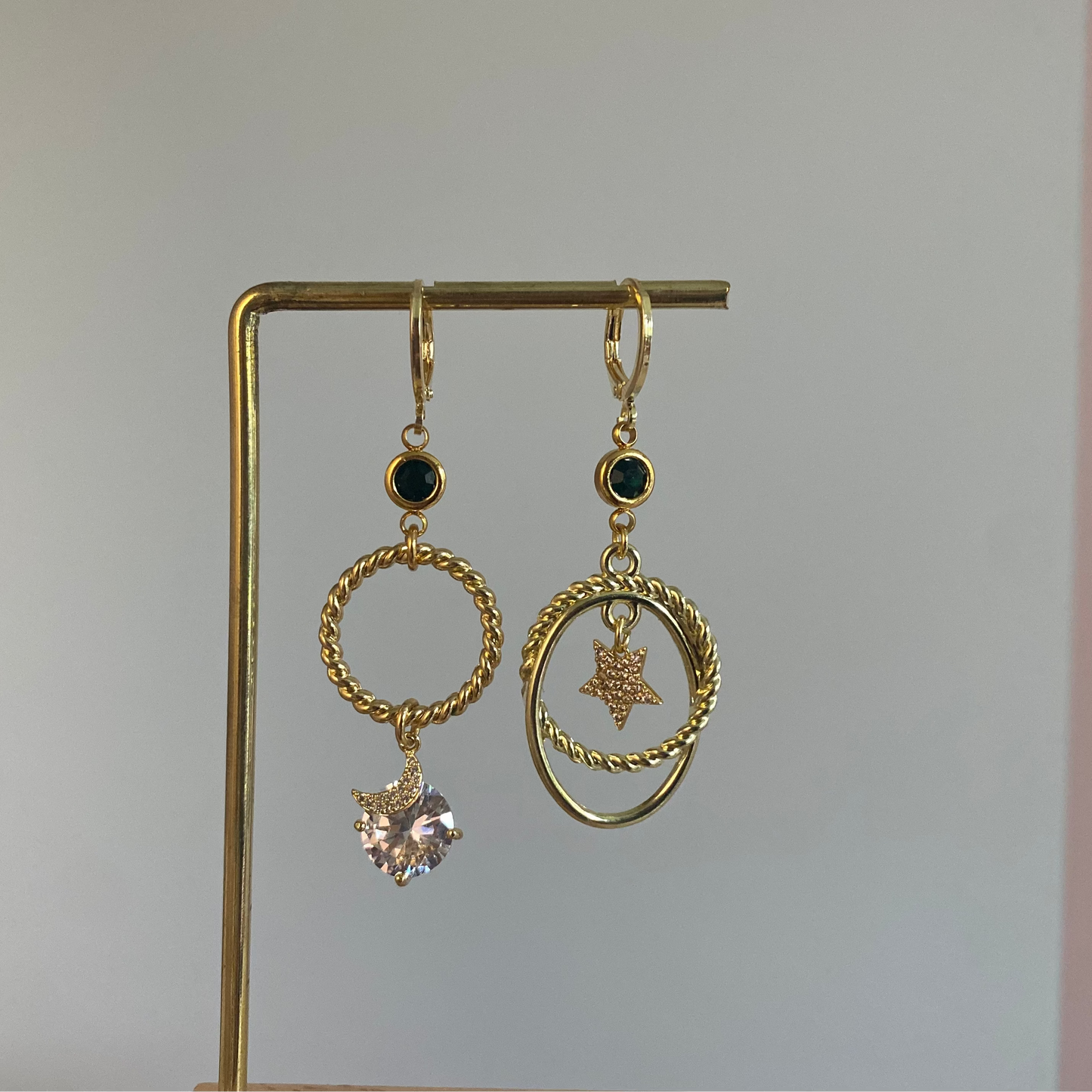Asymmetrische 14k vergulde oorbellen met ster en maan, smaragdgroene of magenta steen en zirkonia details, feestelijke Noelle oorbellen.