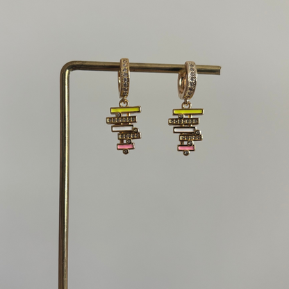 zirkonia oorringen met een hangende bedel van gestapelde geometrische balkjes in geel, wit en roze emaille, bezet met kleine glimmende steentjes.
