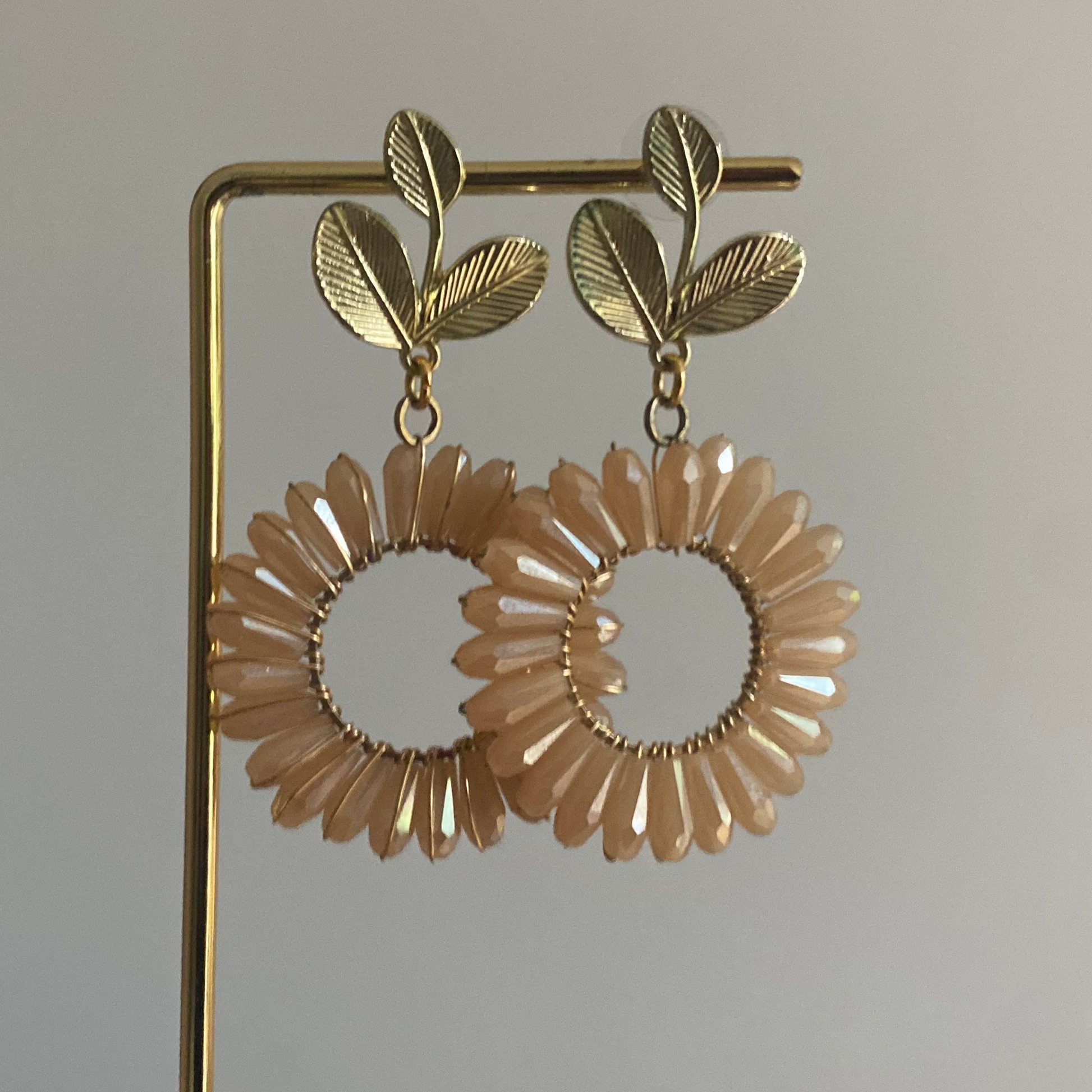 Statement bloem oorbellen met 14K vergulde blad stekers en een bloemachtige hanger in beige 