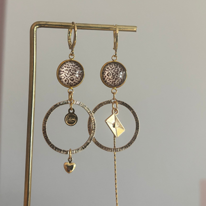 Asymmetrische 14k vergulde feestoorbellen met gehamerde bedels — één met envelopje, één met hartje. Elegant, symbolisch en sprankelend.