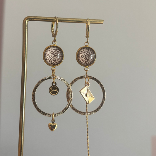 Asymmetrische 14k vergulde feestoorbellen met gehamerde bedels — één met envelopje, één met hartje. Elegant, symbolisch en sprankelend.