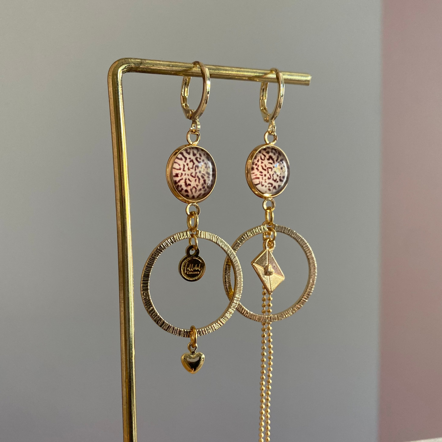 Asymmetrische 14k vergulde feestoorbellen met gehamerde bedels — één met envelopje, één met hartje. Elegant, symbolisch en sprankelend.