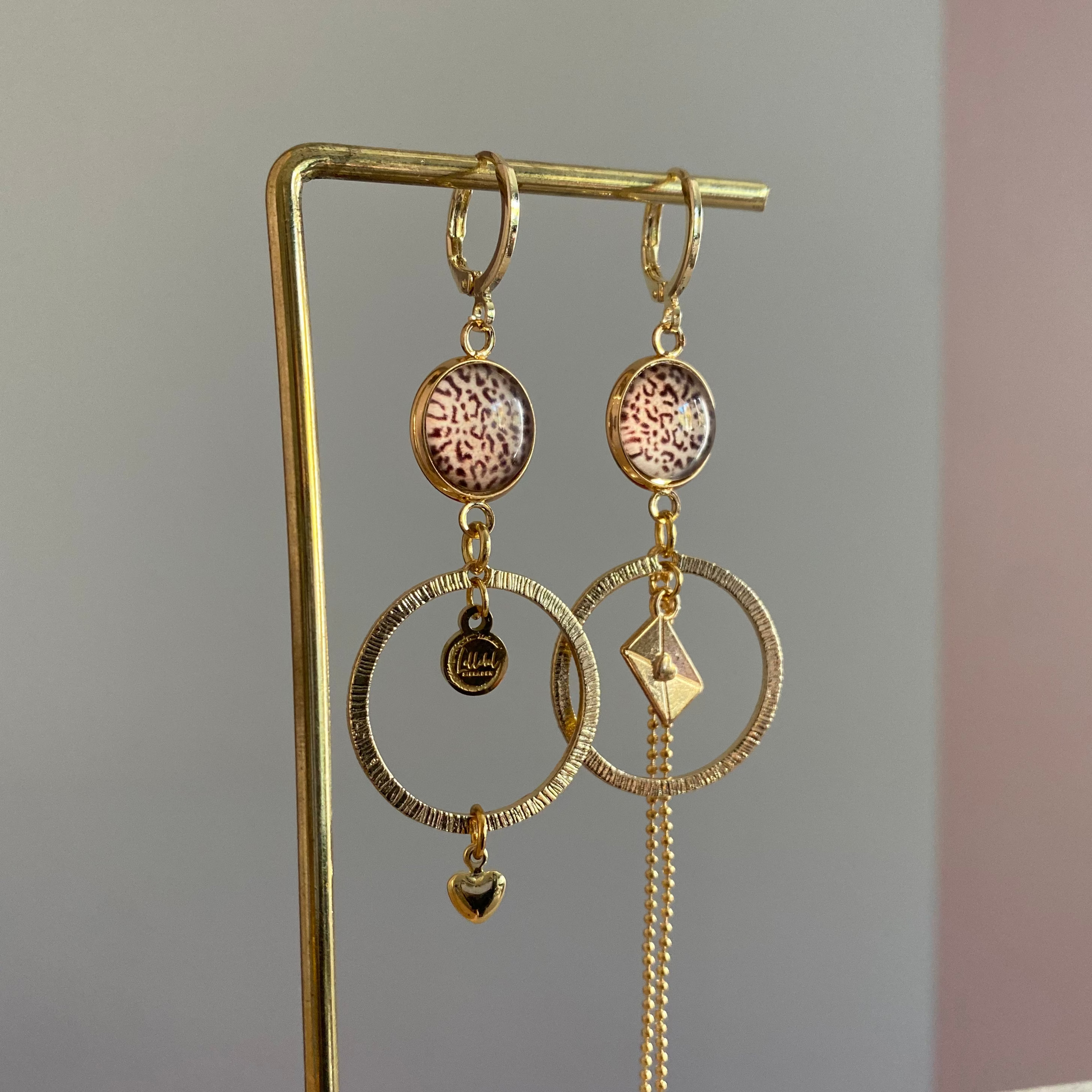 Asymmetrische 14k vergulde feestoorbellen met gehamerde bedels — één met envelopje, één met hartje. Elegant, symbolisch en sprankelend.