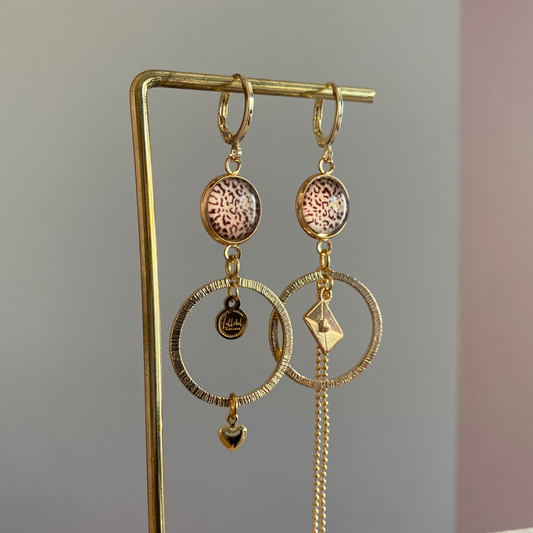 Asymmetrische 14k vergulde feestoorbellen met gehamerde bedels — één met envelopje, één met hartje. Elegant, symbolisch en sprankelend.