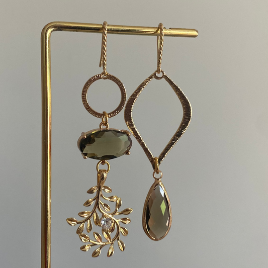 Asymmetrisch oorbelpaar met taupe glasbedel, 14k vergulde takvormige bedel en gehamerde druppel