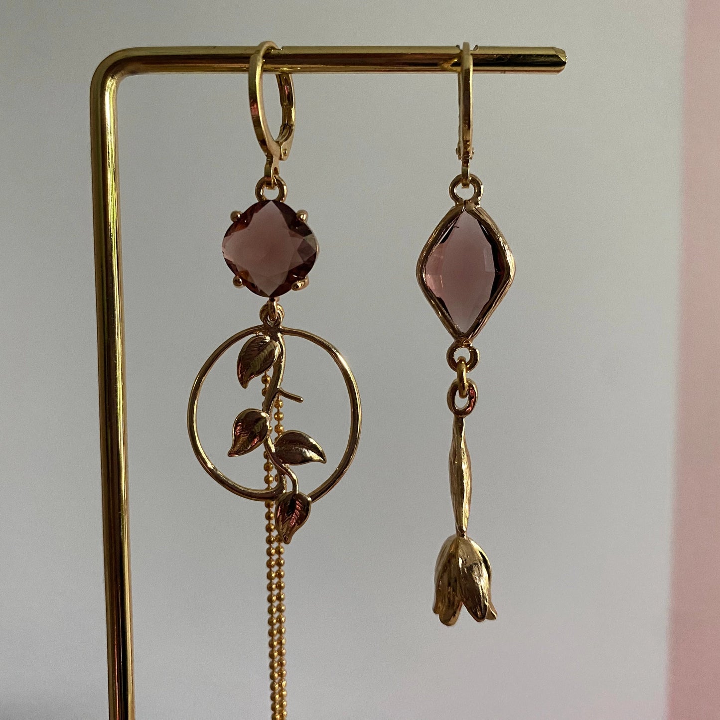 Close-up van Handgemaakt asymmetrisch paar 14K verguld met tulp en blad bedel en burgundy glasbedels 
