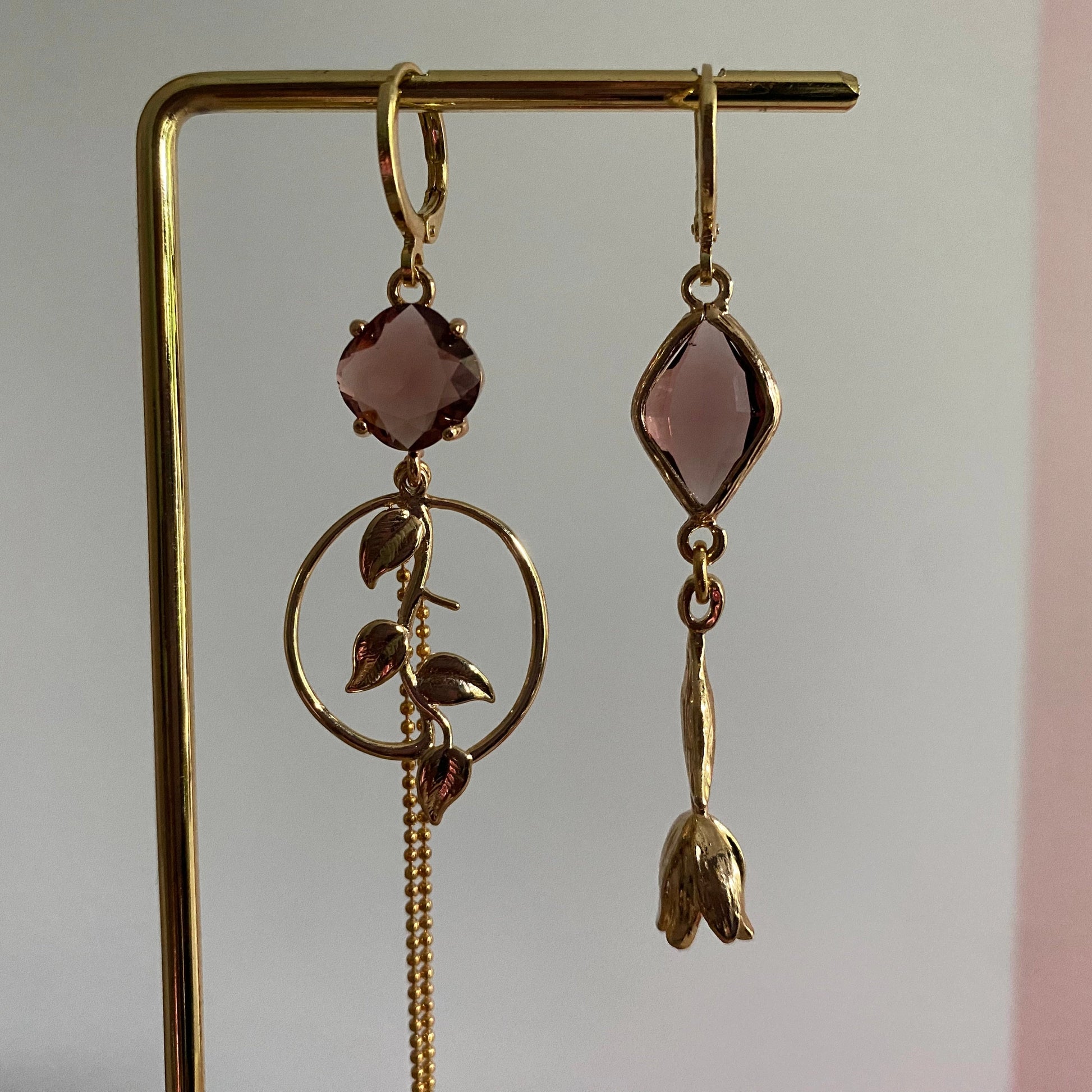 Close-up van Handgemaakt asymmetrisch paar 14K verguld met tulp en blad bedel en burgundy glasbedels 