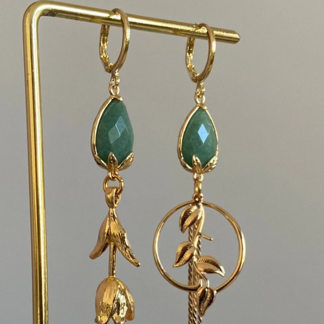 Asymmetrische 14K vergulde oorbellen met natuurstenen bedel en afgewerkt en 14K vergulde tulpen en bladeren. 