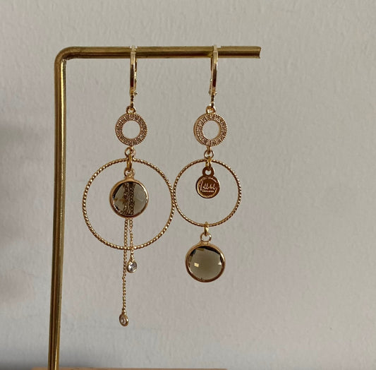 Een productfoto van het ongelijke paar Lellebel Oorbellen "Sandra", met zirkonia hangers en taupe kleurige glasbedels.