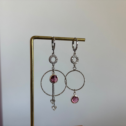 Een foto van mismatch paar oorbellen Sandra Zilver, met de roze glasbedels.