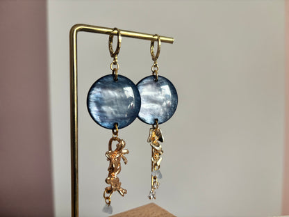 Gouden 14k vergulde asymmetrische oorbellen Senne met ronde blauwgrijze hangers en bloemdetails.