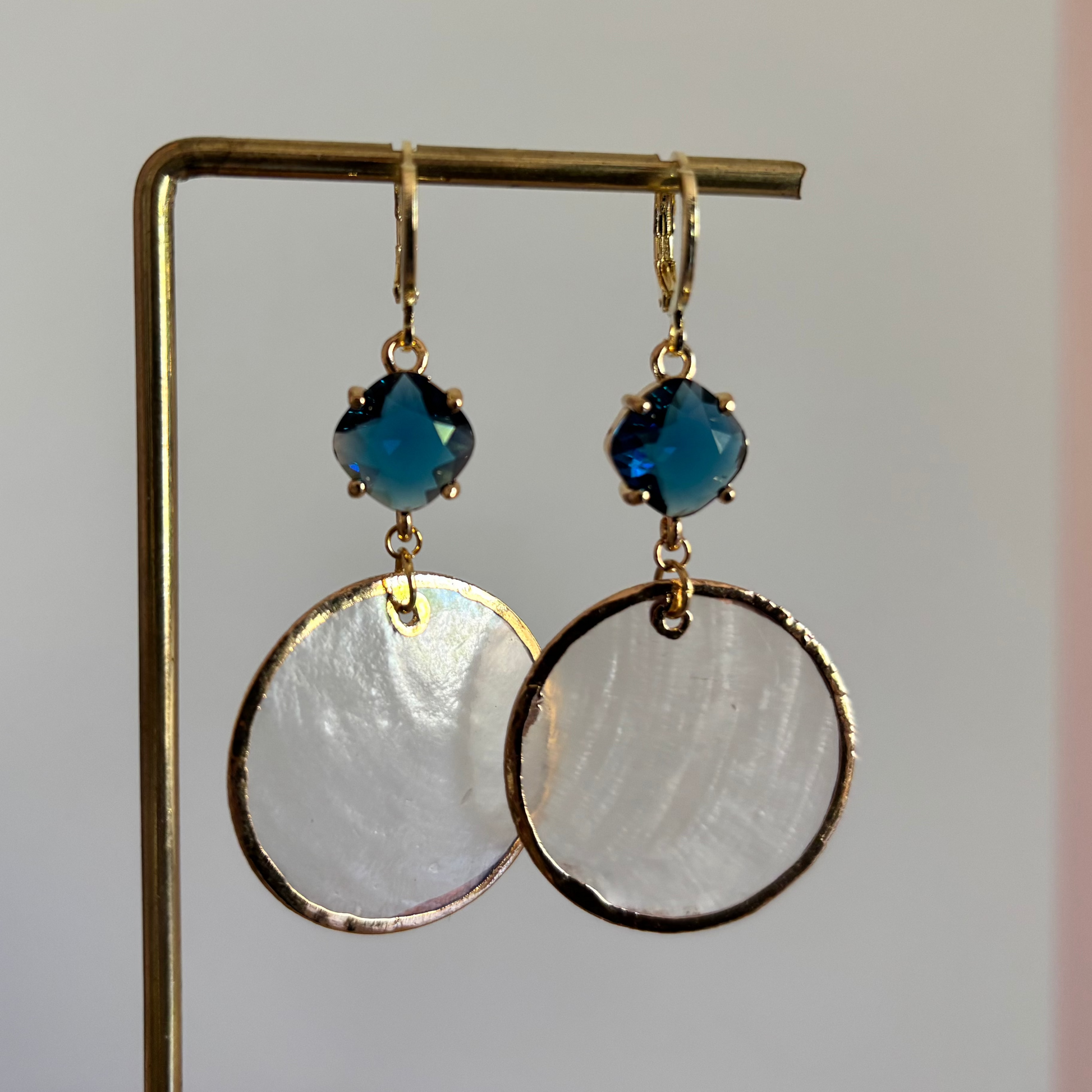 ronde schelpoorbellen met blauwe glasbedel en 14K gouden details