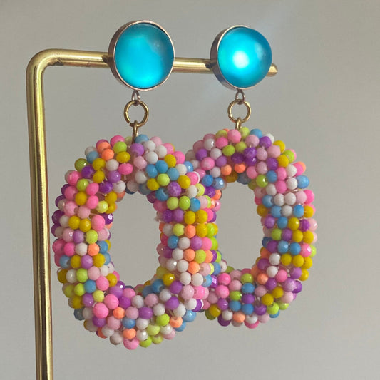 Statementoorbel van neonkleurige kraaltjes aan een neonblauwe cabochon steker.