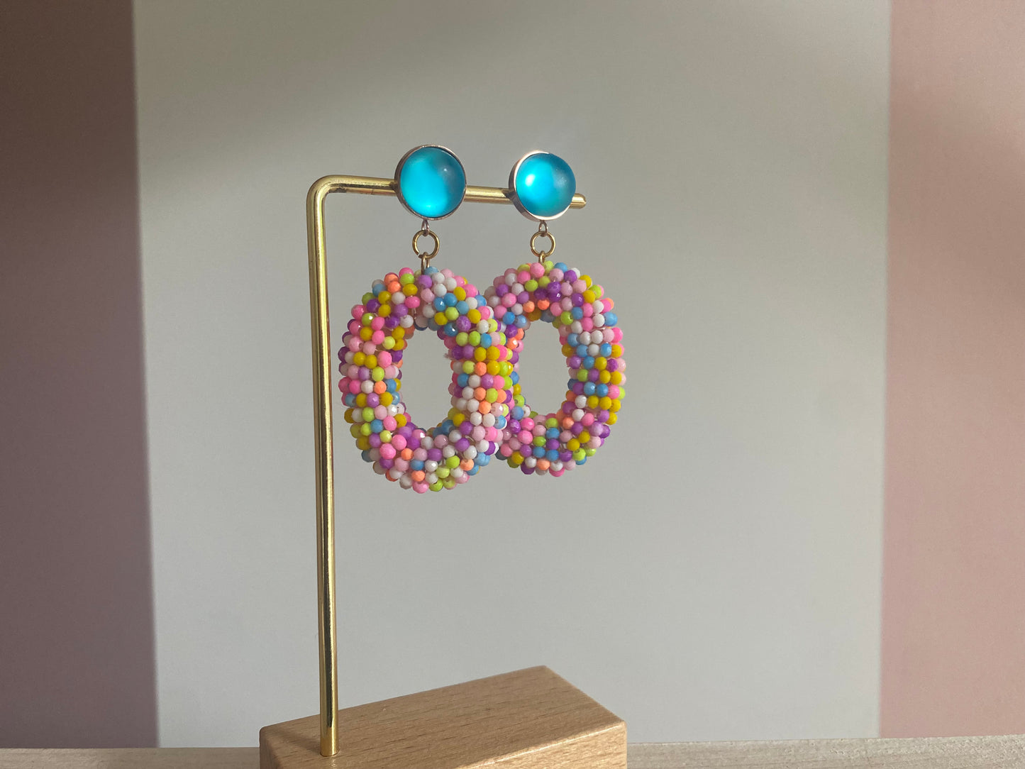 Statementoorbel van neonkleurige kraaltjes aan een neonblauwe cabochon steker.