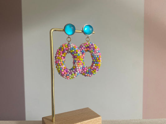 Statementoorbel van neonkleurige kraaltjes aan een neonblauwe cabochon steker.