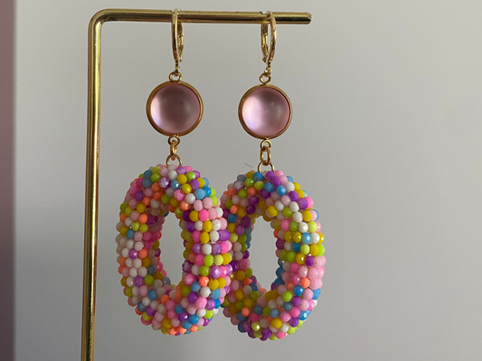 Statementoorbel van neonkleurige kraaltjes aan een lichtroze cabochon steker.