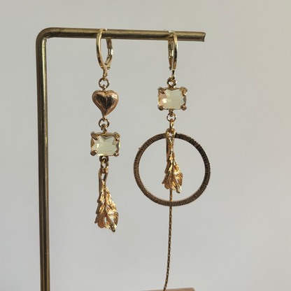 Veertje mismatch oorbellen goud met veer, hartje, glasbedel en kwastje, asymmetrisch design