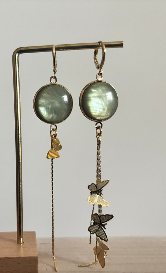 Lange 14k vergulde oorbellen 'Vlinder' met pastelgroene stenen en fijne gouden kettinkjes met vlinderbedeltjes.