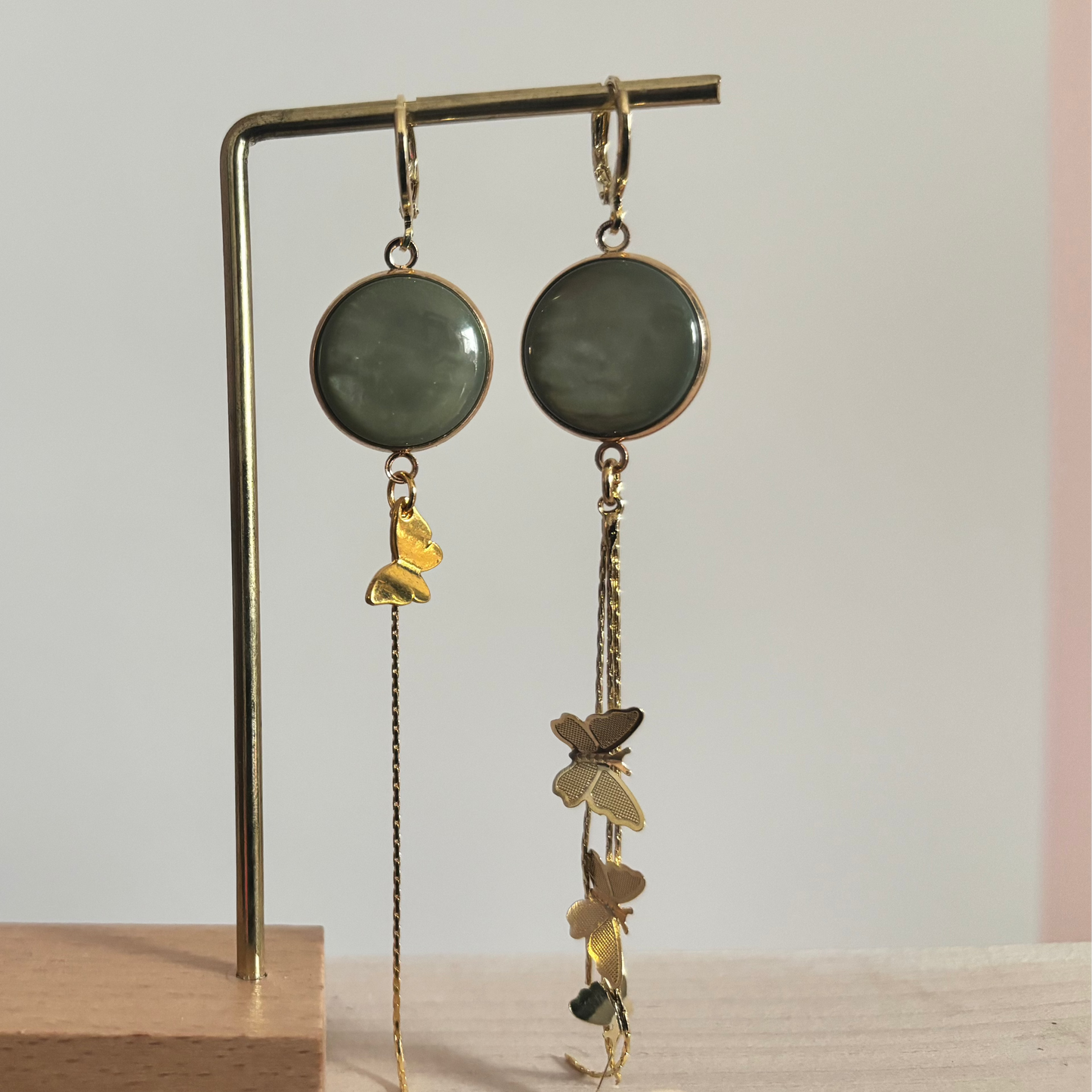 Lange 14k vergulde oorbellen 'Vlinder' met pastelgroene stenen en fijne gouden kettinkjes met vlinderbedeltjes.