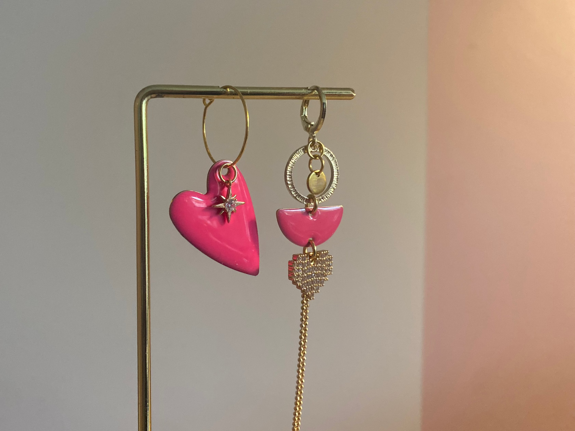 Asymmetrisch paar met links een emaille hart en rechts 14K vergulde bedels en zirkonia afgewisseld met een emaille bedel in fuchsiaroze
