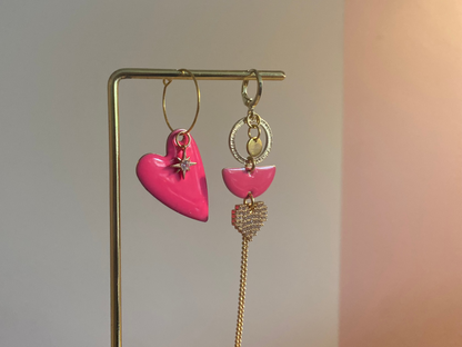 Asymmetrisch paar met links een emaille hart en rechts 14K vergulde bedels en zirkonia afgewisseld met een emaille bedel in fuchsiaroze