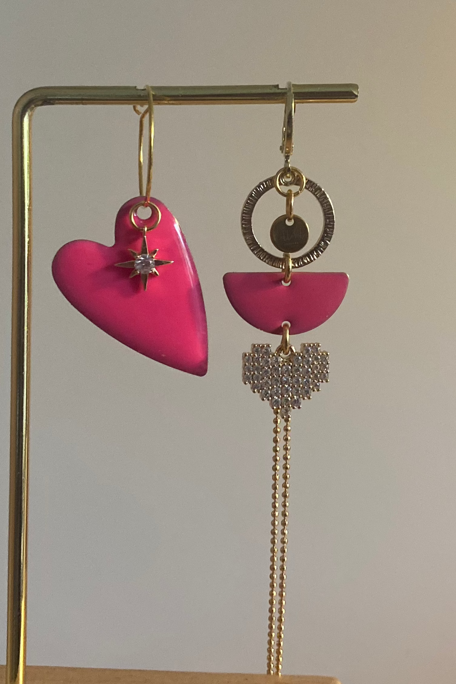 Asymmetrisch paar met links een emaille hart en rechts 14K vergulde bedels en zirkonia afgewisseld met een emaille bedel in fuchsiaroze
