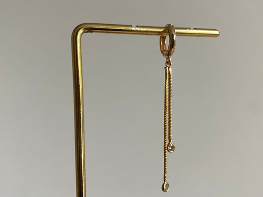 Handgemaakte 14K vergulde oorbel met daaraan een 14K vergulden gouden strengetje met zirkonia bedels.