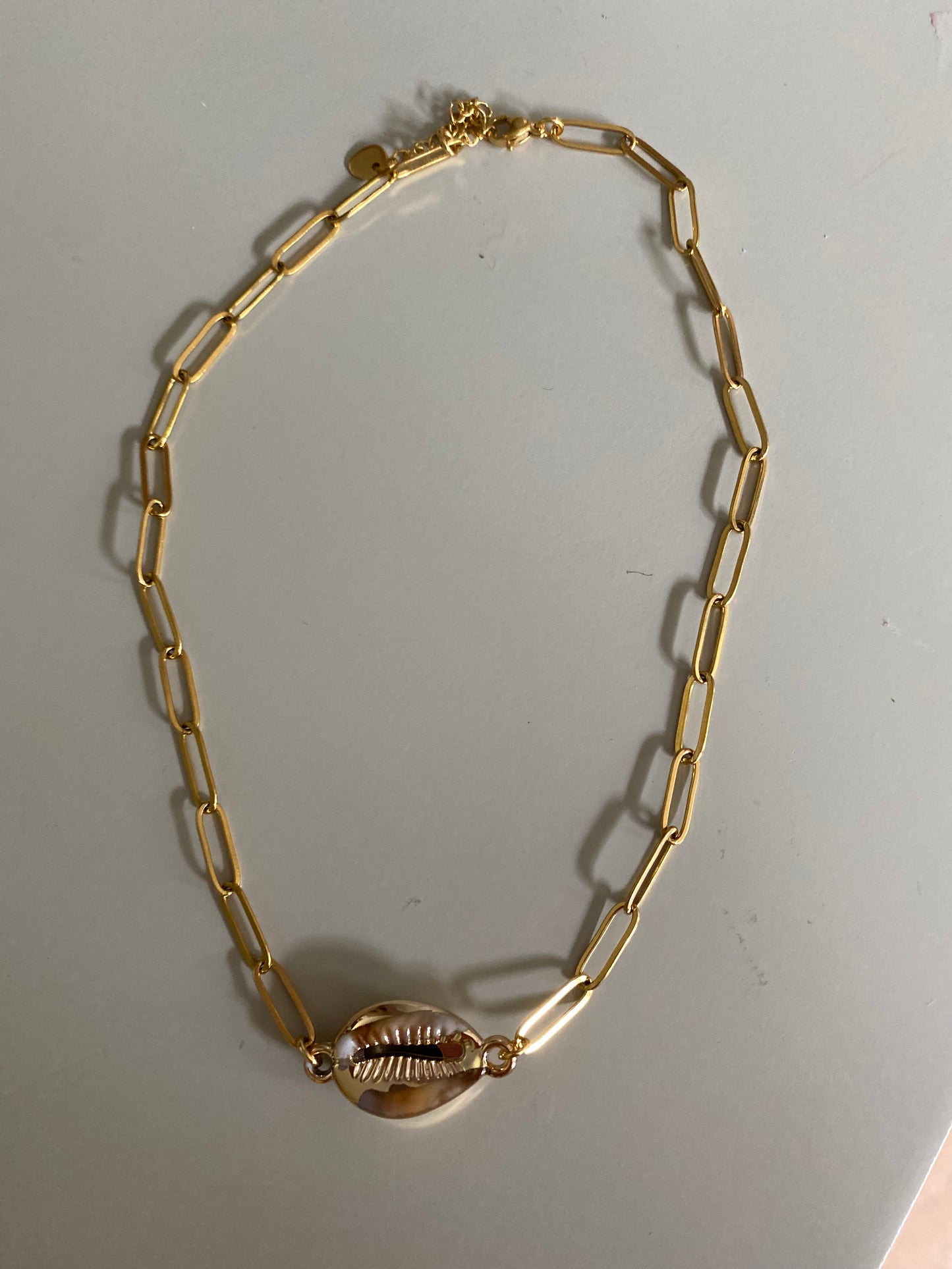 Handgemaakte RVS goldplated schakelketting met in het midden een schelpbedel.