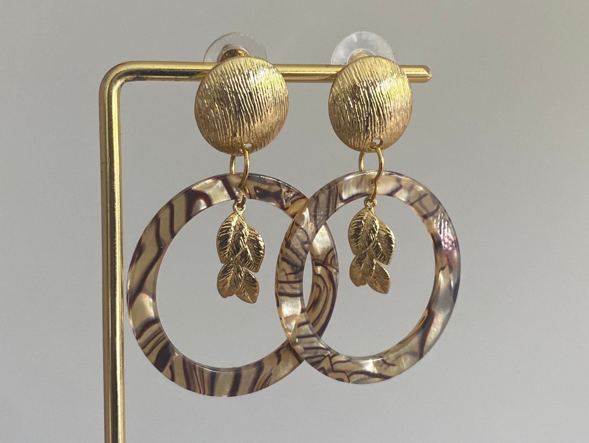 Gemarmerde resin hanger met 14K vergulde bladbedel aan een 14K vergulde gehamerde steker.